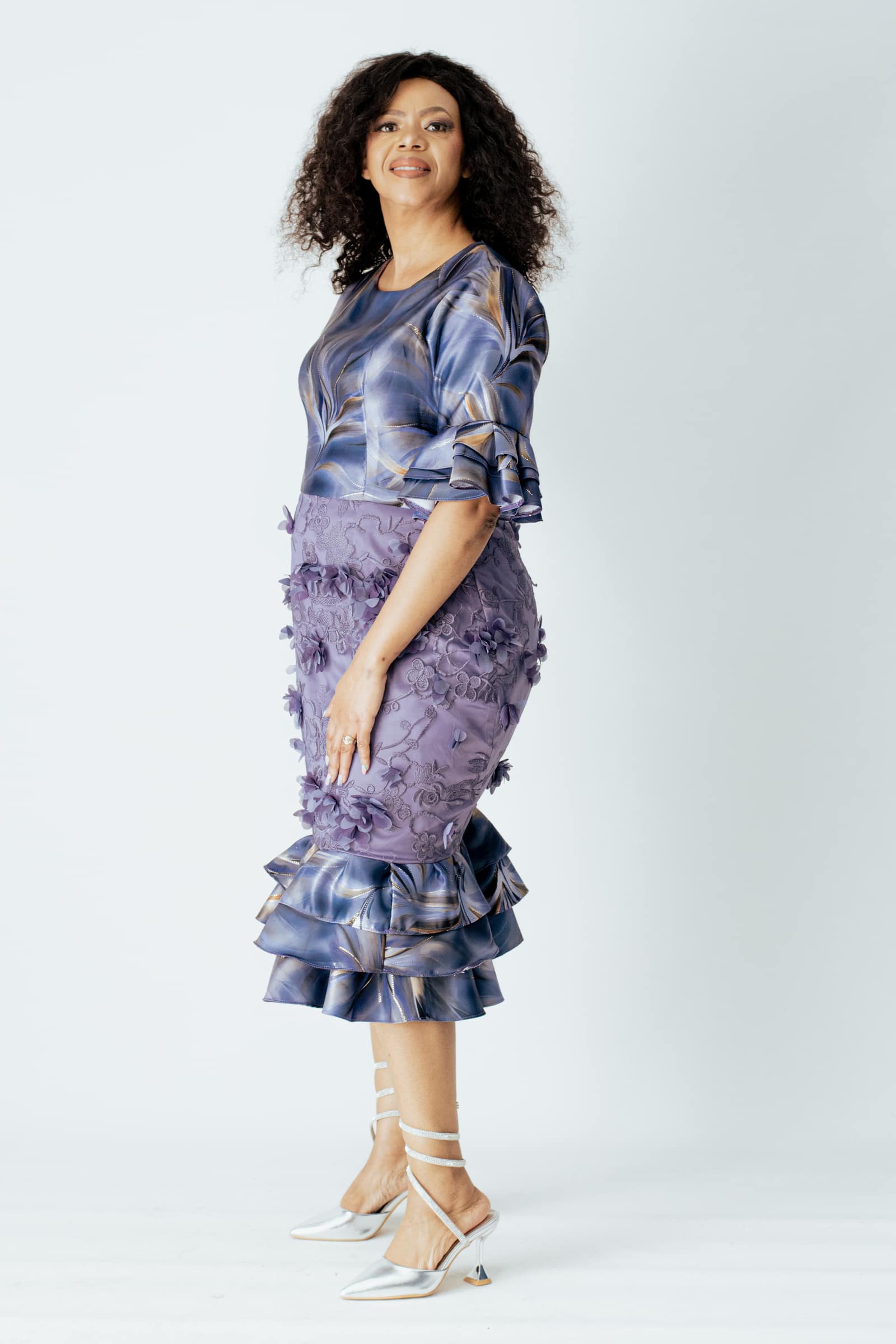 Full-length studio portrait of a woman in a blue and purple formal dress